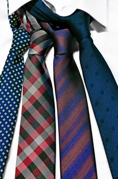 Stack of neck ties on white shirt — Stock Photo, Image