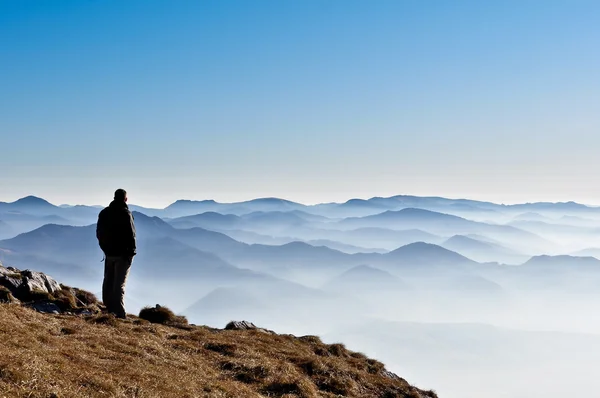 Mistige berg heuvels en man silhouet — Stockfoto