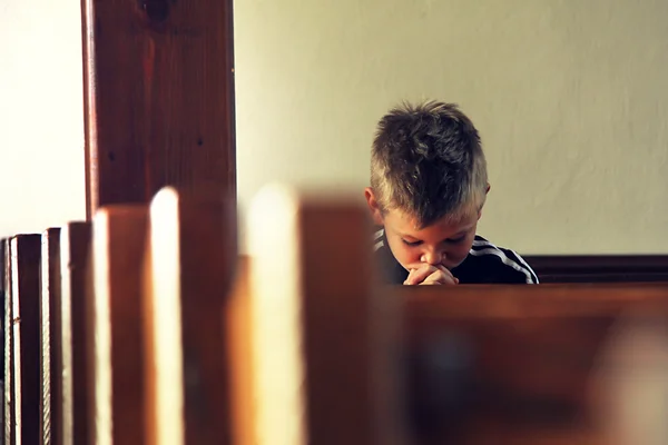 O rapaz está a rezar. Imagem De Stock