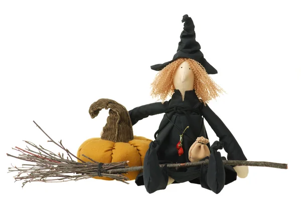 Stuffed witch toy with broom and pumpkin Stock Picture