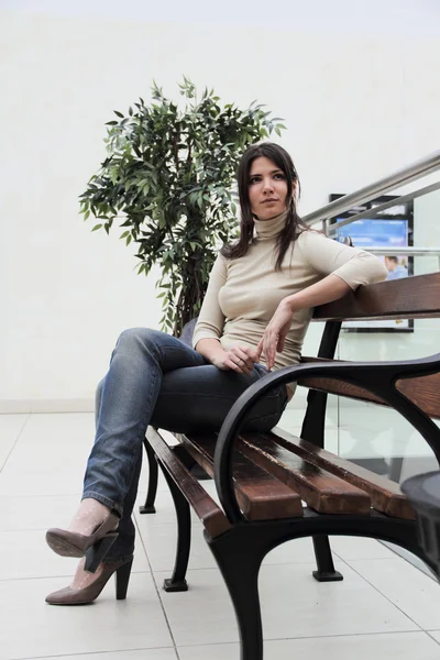 Junge Frau sitzt auf Bank — Stockfoto