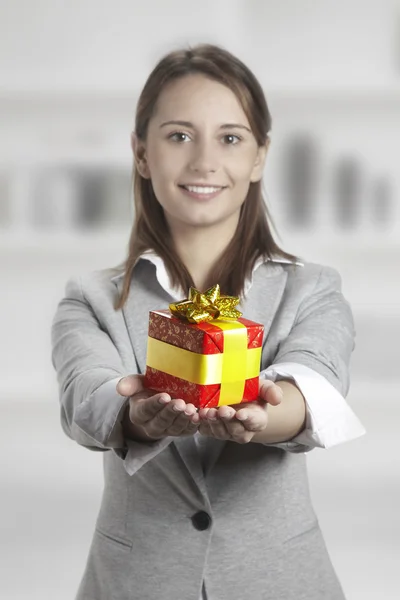 Business young woman holding present — Stock Photo, Image