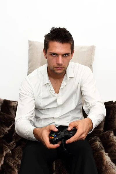Gamer sitter på soffan med controller och spela — Stockfoto