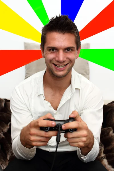 Smiling Gamer sitting on couch with controller and playing — Stock Photo, Image