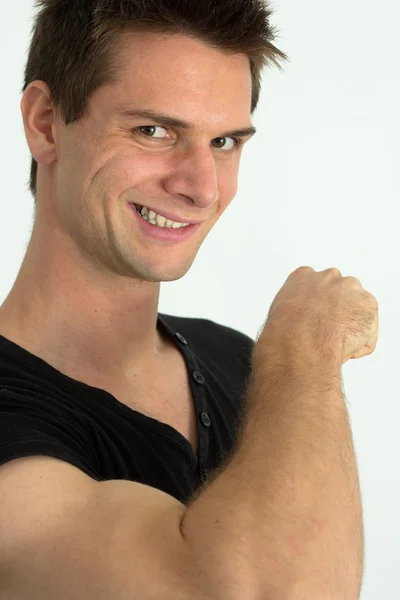 Hombre mostrando sus músculos del brazo y sonriendo —  Fotos de Stock