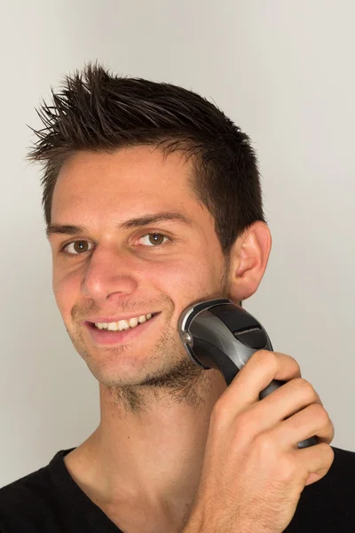 Hombre afeitado cara con maquinilla de afeitar eléctrica —  Fotos de Stock