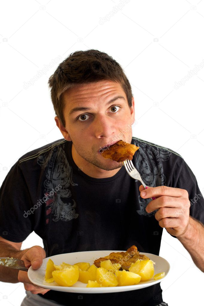 Young man eating a Schnitzel and potatoes
