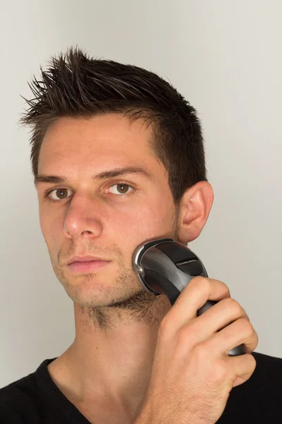 Hombre afeitado cara con maquinilla de afeitar eléctrica —  Fotos de Stock