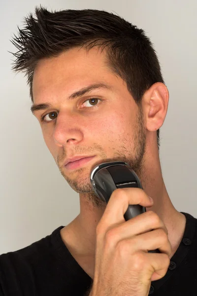 Hombre afeitado cara con maquinilla de afeitar eléctrica — Foto de Stock