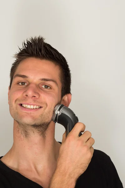 Άνθρωπος πρόσωπο ξύρισμα με ηλεκτρική ξυριστική μηχανή — Φωτογραφία Αρχείου