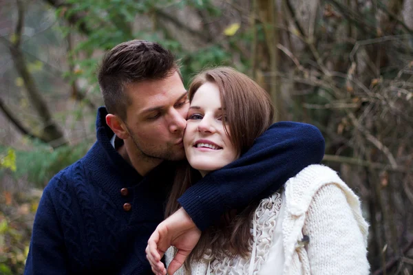 Mann kysser kvinne på kinnet – stockfoto