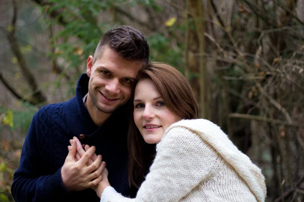 Et ungt par som holder hender og smiler lykkelig – stockfoto