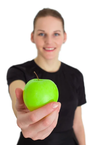 Vrouw die een groene appel en glimlachen — Stockfoto