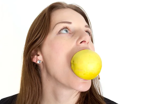 Donna che morde una mela gialla — Foto Stock