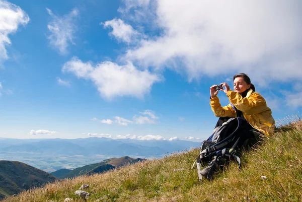 Молодая женщина в горах - фотографирует — стоковое фото