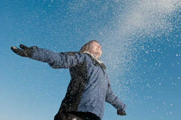 Njuter av vintern - kvinna kastar snö — Stockfoto
