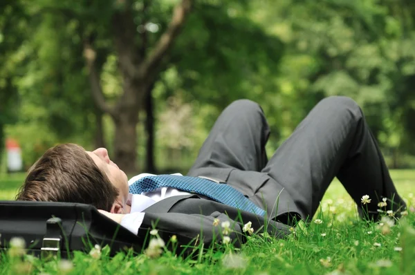 Senior zakenman liggen in gras — Stockfoto