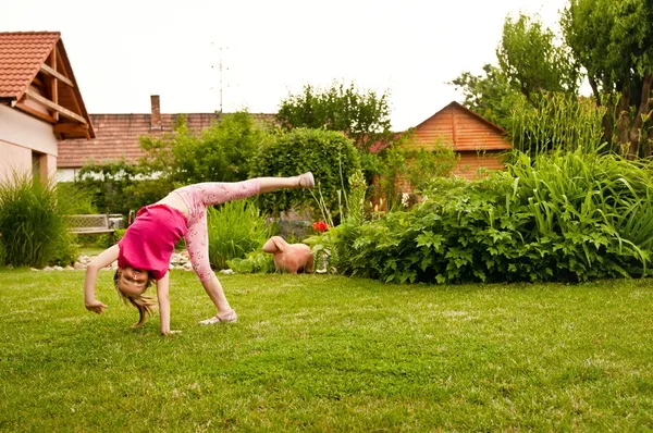 Child doing cartwheel in backyard — Stock Photo, Image