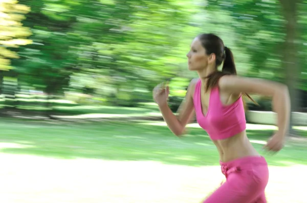 Mujer joven corriendo al aire libre - movimiento borroso — Foto de Stock