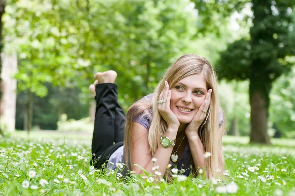 Young beautiful woman lying outdoors — Stock Photo, Image