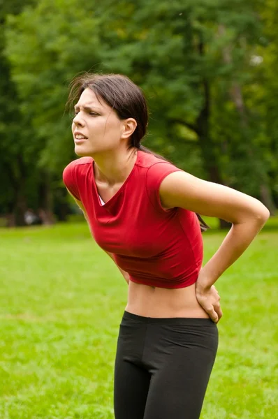 Rückenschmerzen - Sportlerin mit Schmerzen — Stockfoto