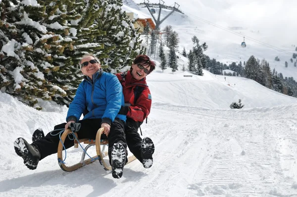 Senior couple on sledge having fun — Stock Photo, Image