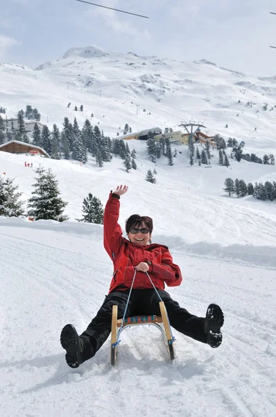Senior woman on sledge having fun — Stock Photo, Image