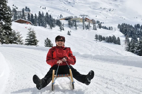 Senior woman on sledge having fun — Stock Photo, Image