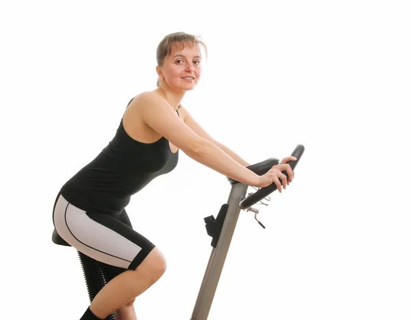 Mujer fitness haciendo ejercicio en bicicleta giratoria desde atrás - aislado — Foto de Stock
