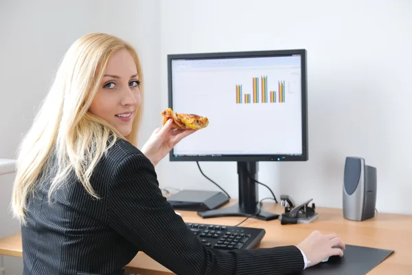 Jovem empresária que come pizza no trabalho — Fotografia de Stock
