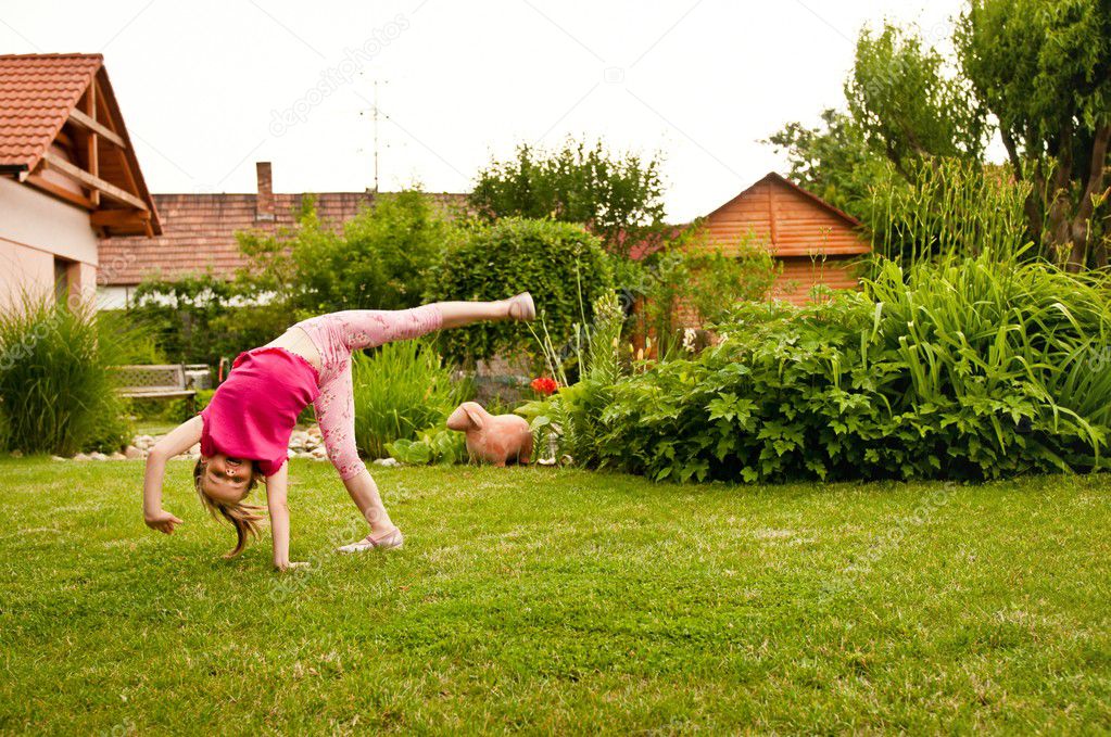 Child doing cartwheel in backyard — Stock Photo © martinan #7171312