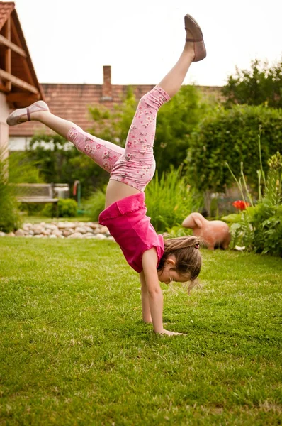 Child doing handstand in backyard — Stock Photo, Image