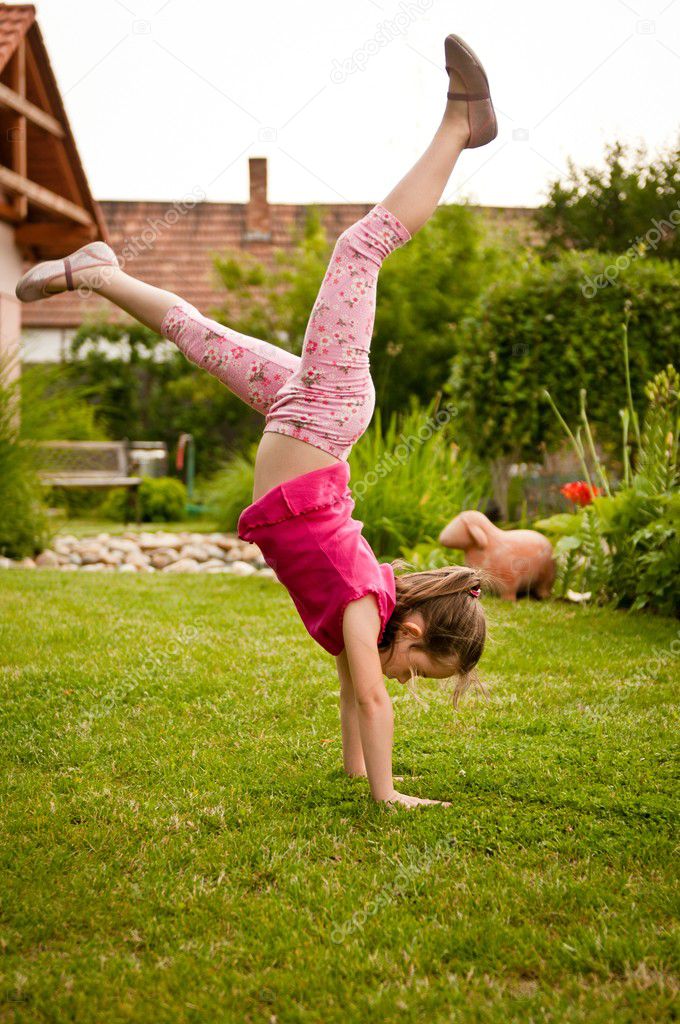 Child doing handstand in backyard