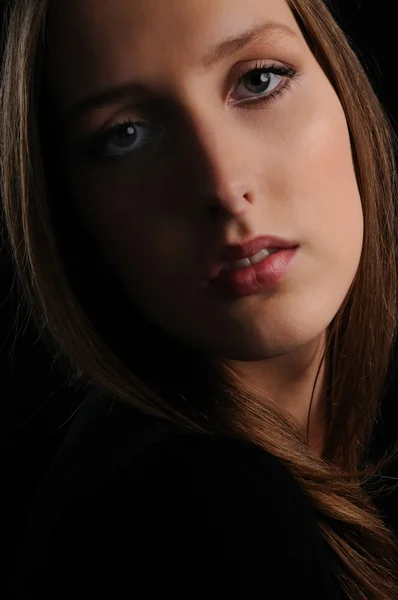 Portrait of young woman on black — Stock Photo, Image