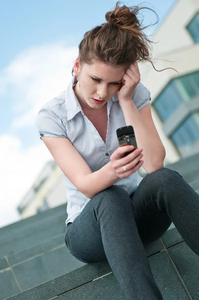 Unhappy woman with mobile phone — Stock Photo, Image