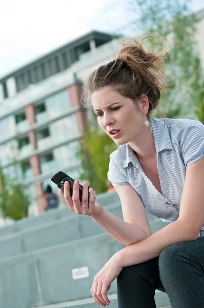 Плохое сообщение - несчастная женщина с мобильным телефоном — стоковое фото
