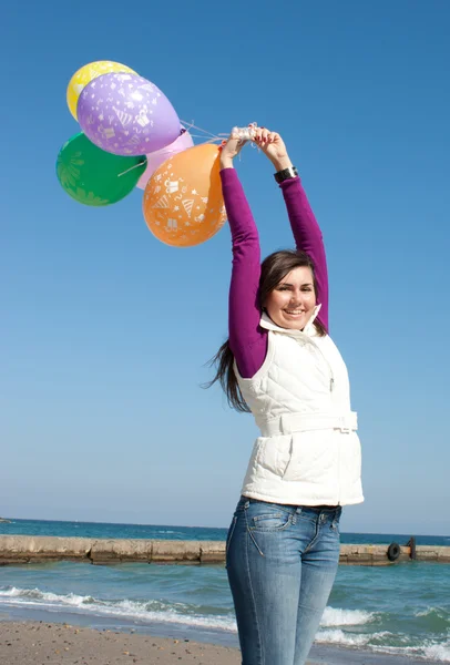 Улыбающаяся девушка держит воздушные шары — стоковое фото