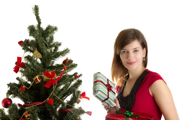 Красивая женщина с подарками возле елки — стоковое фото