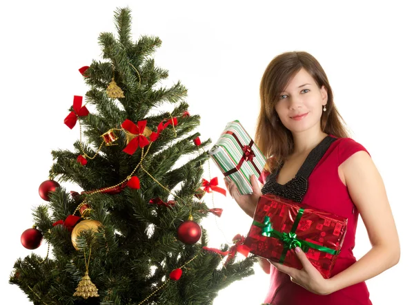 Beautiful woman with presents near Christmas tree — Stock Photo, Image