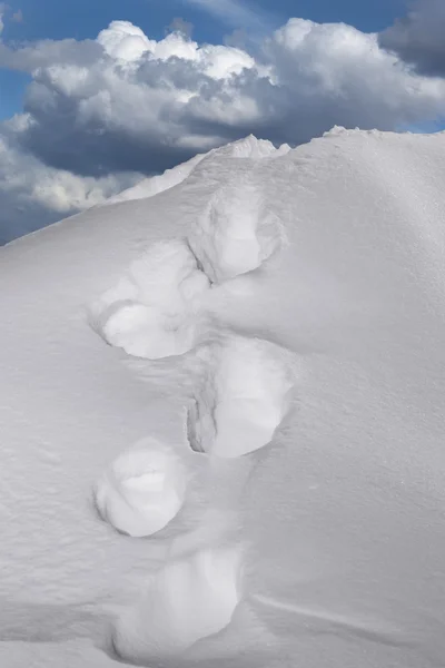 Footsteps in snow on mountain — Stock Photo, Image