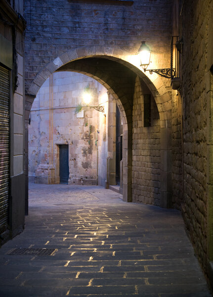 Narrow street with archway in the Old Town of Barcelona, Spain.