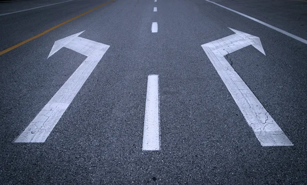 Signos de flecha sobre asfalto —  Fotos de Stock