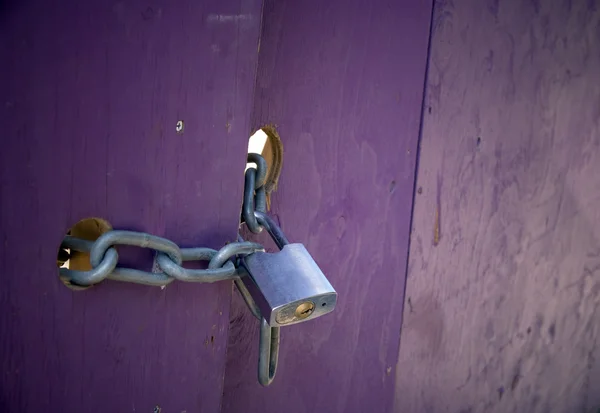 Padlock op paarse deur — Stockfoto