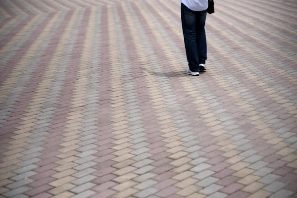 Pessoa que caminha na estrada pedonal ladrilhada — Fotografia de Stock