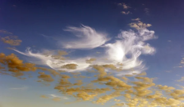 Голубое небо с белыми и желтыми облаками — стоковое фото