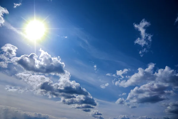 Bright sun and white fluffy clouds Royalty Free Stock Images