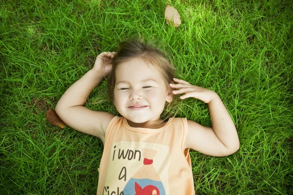 Ребенок, лежащий на траве — стоковое фото