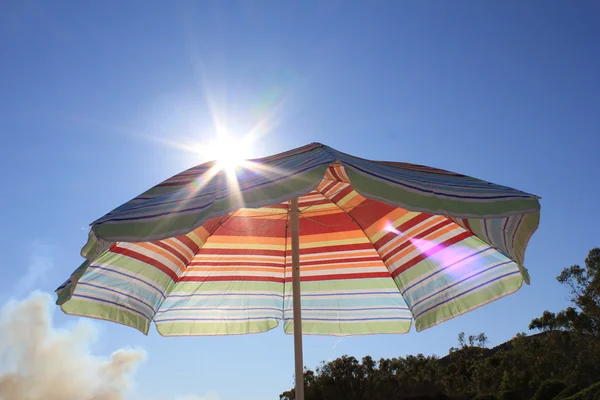Kleurrijke Strandparasol tegen zonnige blauwe hemel — Stockfoto
