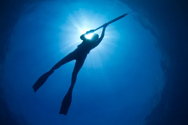 Μια σιλουέτα μιας νεαρής γυναίκας υποβρύχια αλιεία — Φωτογραφία Αρχείου