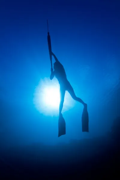 Una chica pesca submarina frente al sol —  Fotos de Stock